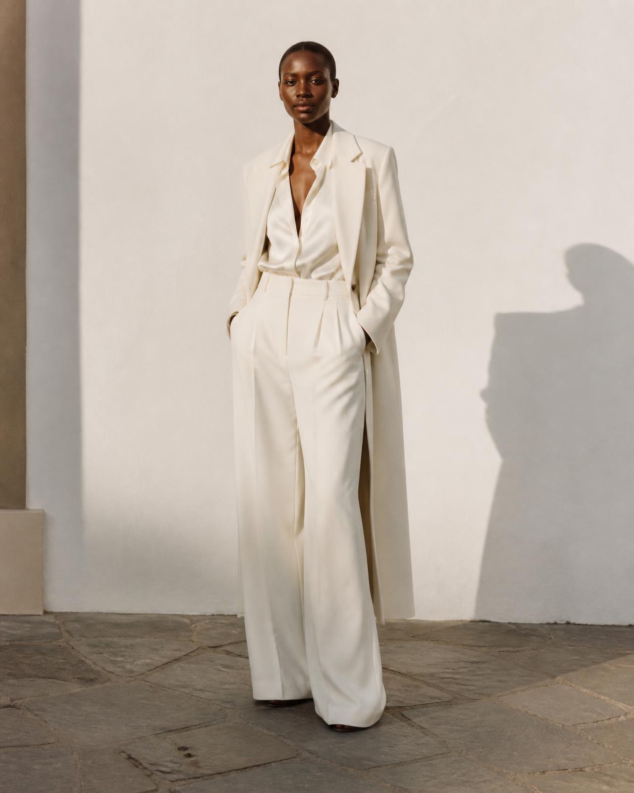 Model in a tailored oatmeal wool coat in afternoon light